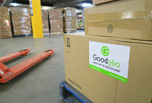 In a warehouse setting, a close up of a box with a Good 360 sticker on it